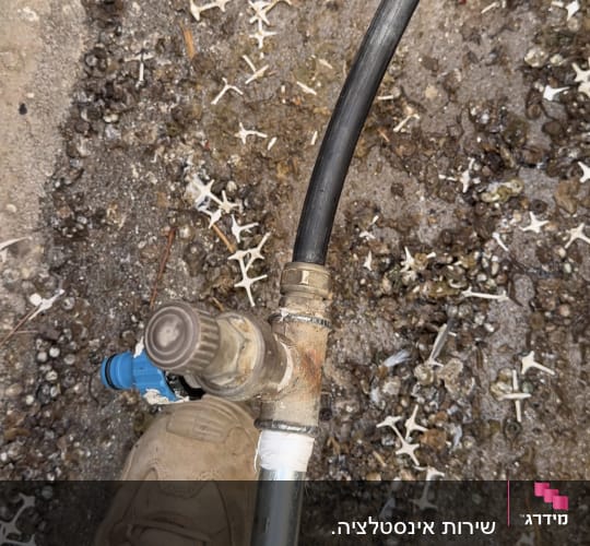 חיבור צנרת מים ונקודת השקיה בחוץ על ידי אינסטלטור
